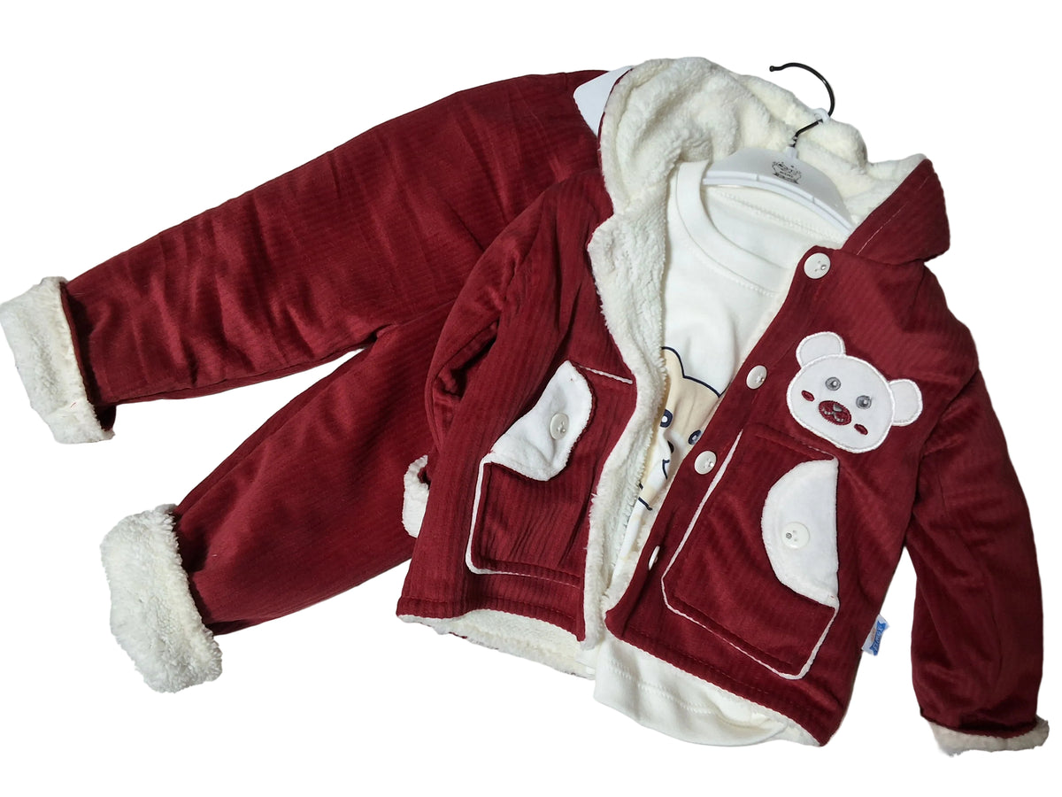 A children's two-piece corduroy jacket and pants set in deep red, featuring a cream sherpa fleece lining and a white bear applique on the jacket pocket, laid flat on a marble-patterned surface.